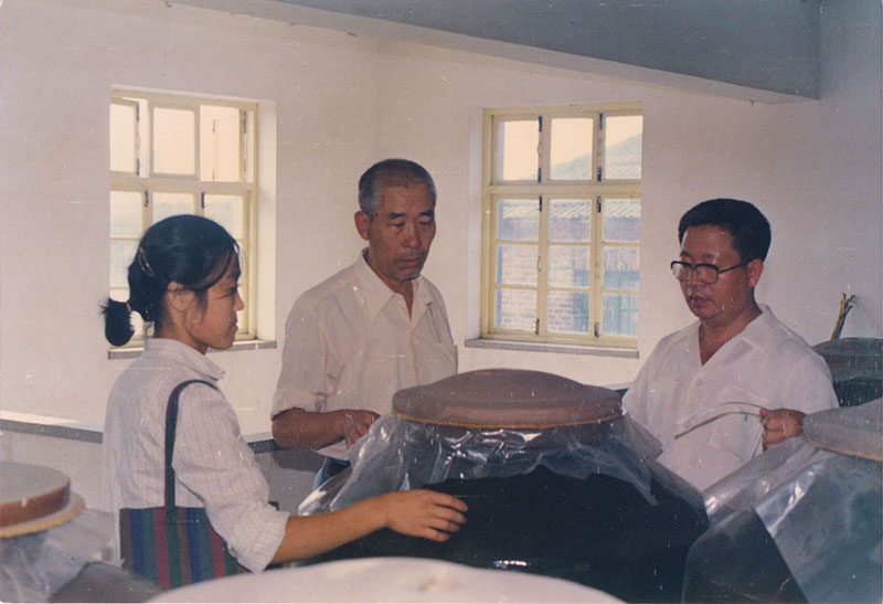 4 1992年，著名(míng)釀酒專家周恒剛（中(zhōng)）在景芝釀酒車(chē)間指導工(gōng)作(zuò).jpg